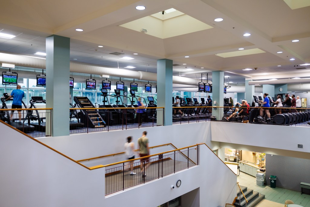 A large gym area with exercise machines and a flight of stairs